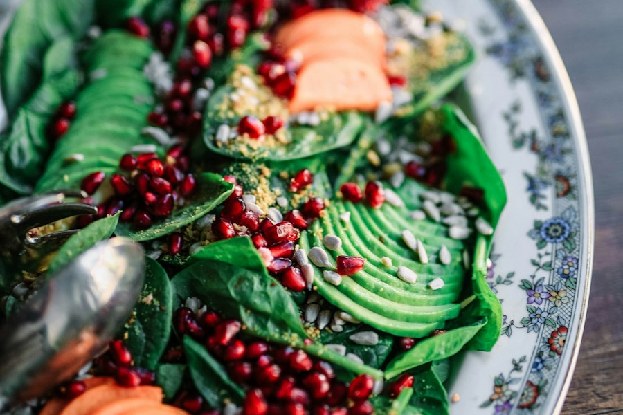 Salat mit Blattgemüse, Avocado, Karotten, Kernen und Granatapfel